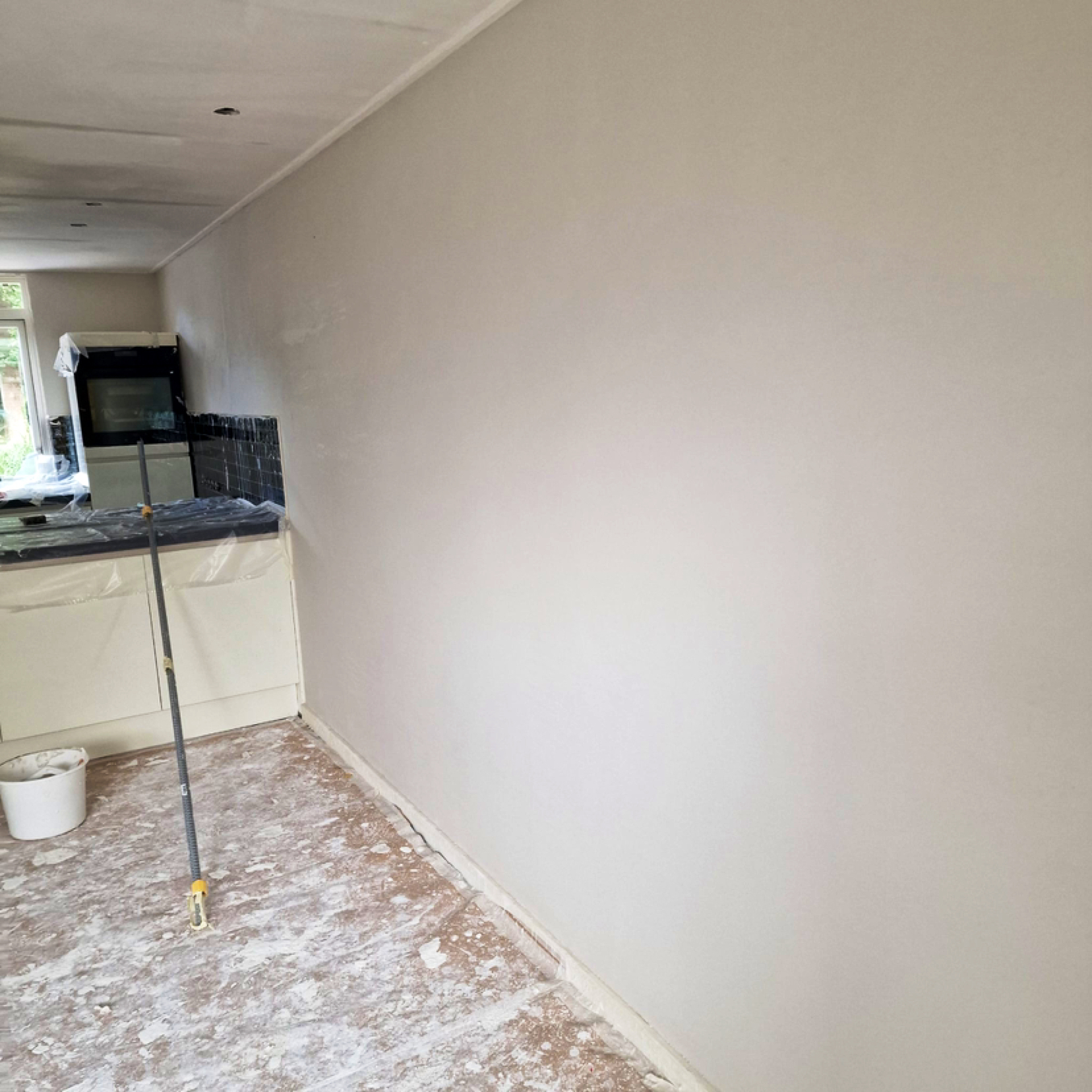 Dezelfde keukenwand na het stucwerk, strak en glad afgewerkt